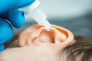 Child getting ears cleaned with peroxide