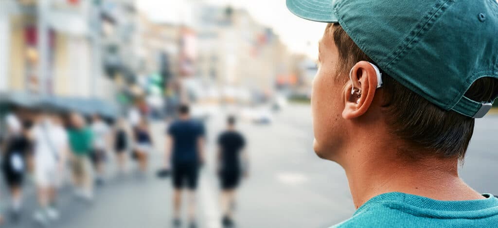 Close-up of a man wearing first hearing aid, adjusting to new hearing experience