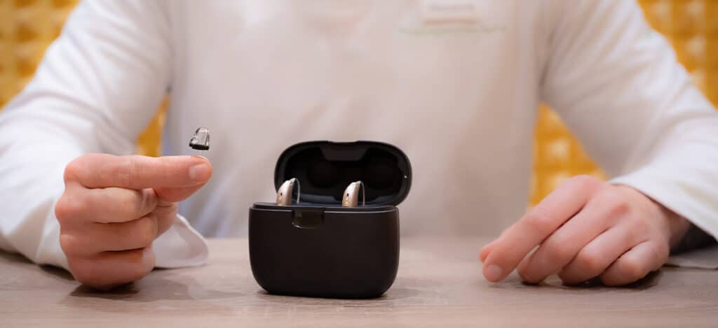 Audiologist presenting different types of hearing aids to a patient